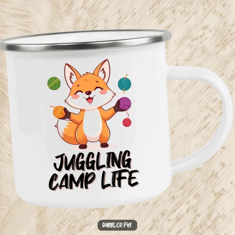 Funny Fox Camping Mug: A playful fox grins while juggling colorful yarn balls, perfect for outdoor brews and crafty campers.