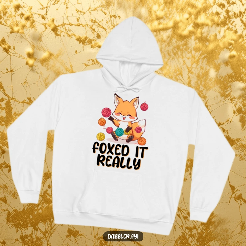 Funny hoodie with a playful fox character juggling colorful yarn balls, offering warmth and crafty charm.